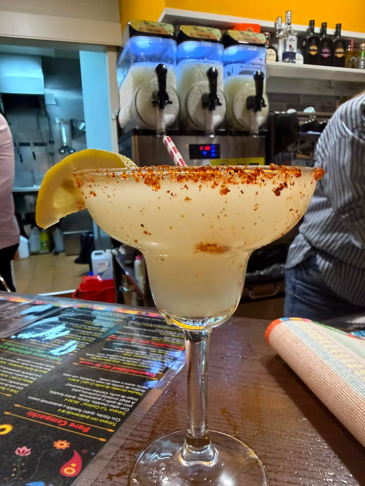 Margarita frozen con tajín y limón, máquinas de frío al fondo